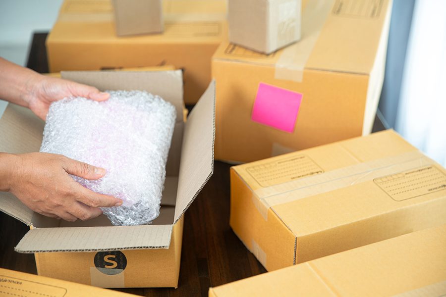 closeup view female packing package shipping box